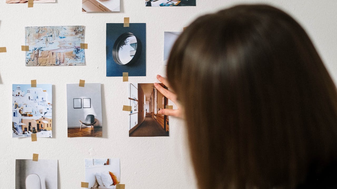 Mother looking at framed photos on a shelf with a warm smile