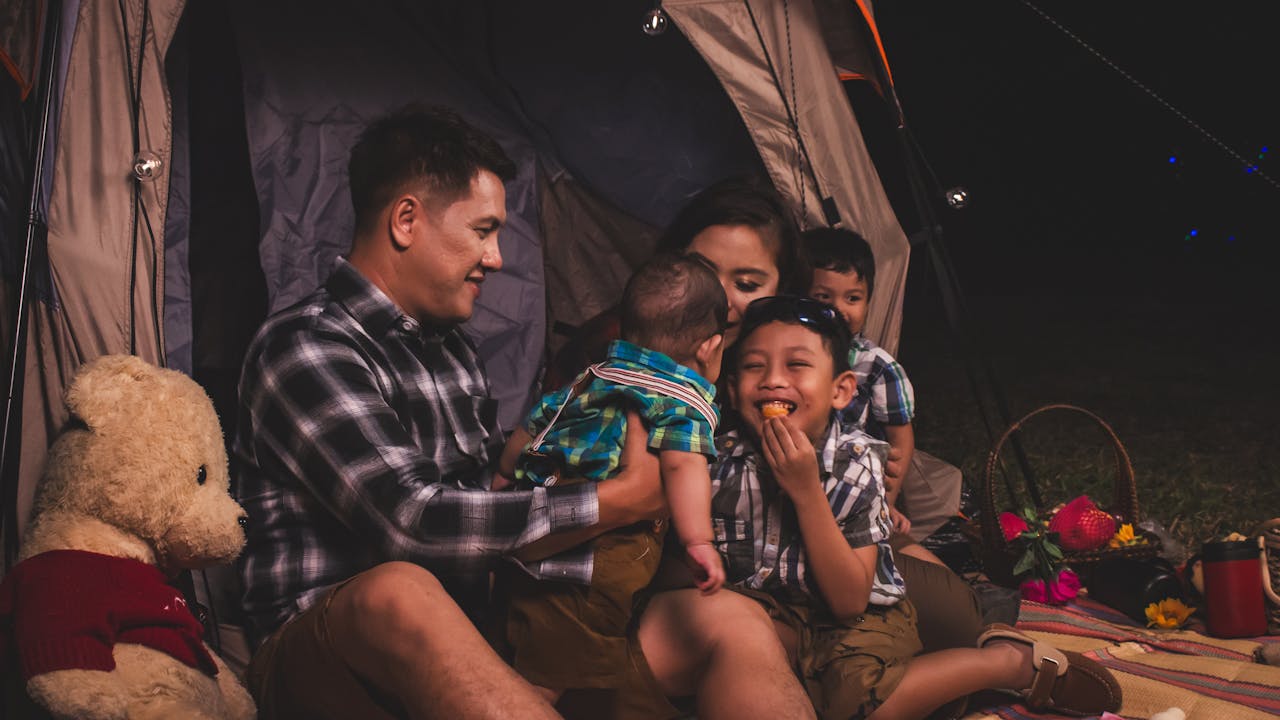 Family setting up a campsite together in a forest