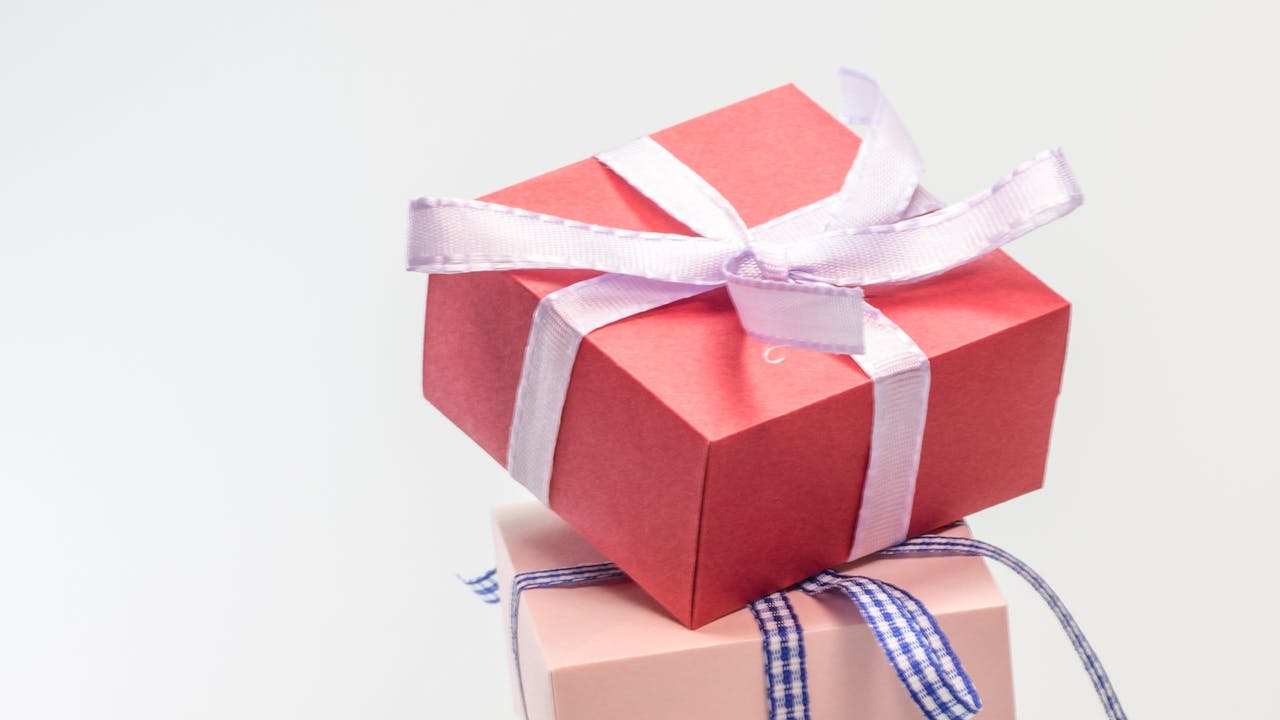 Beautiful wrapped gift basket with ribbon on a table