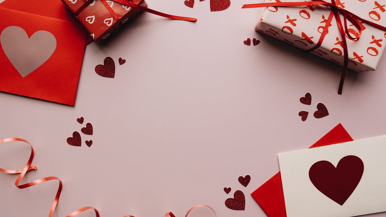 Gift cards and Valentine's envelopes arranged with red ribbons