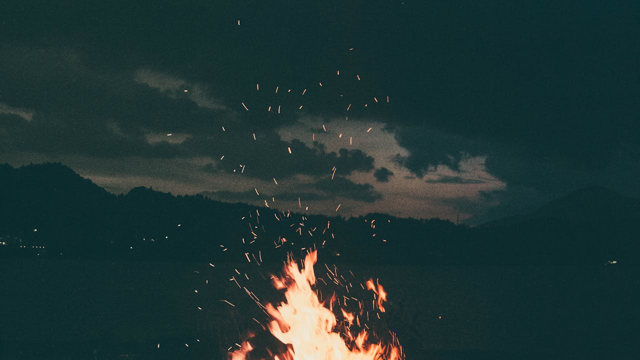 Campfire in wilderness at dusk with warm golden light