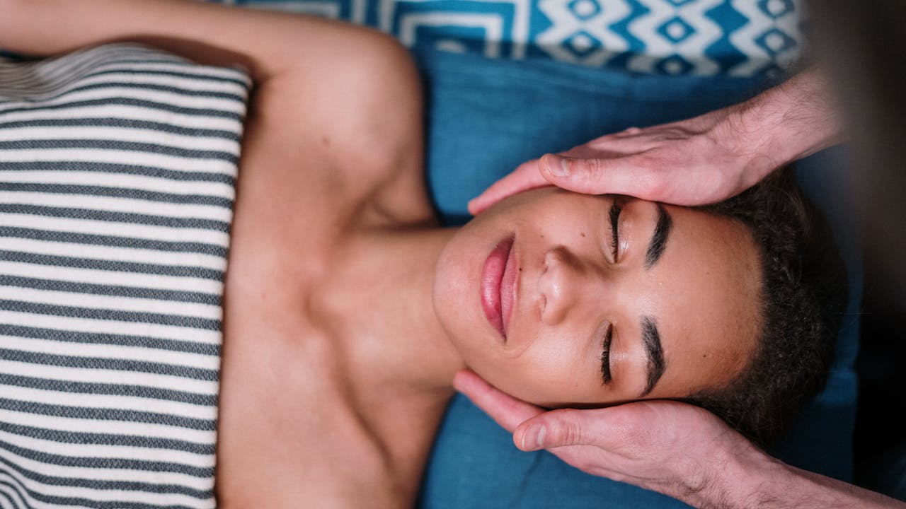 Esthetician performing a relaxing facial treatment on a client in a bright spa room