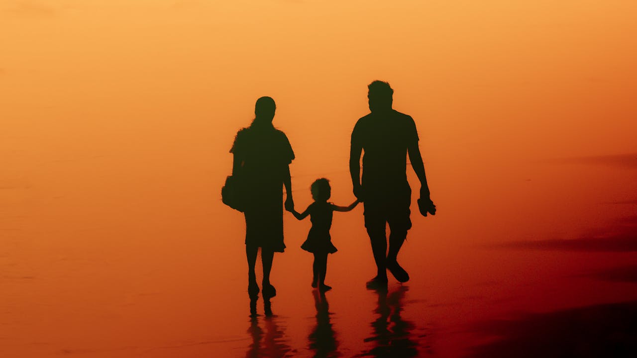 Family silhouette photographed at the beach at golden sunset