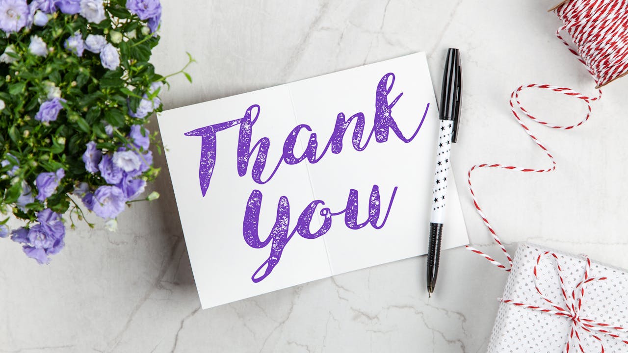 Thank you card and flowers on a desk