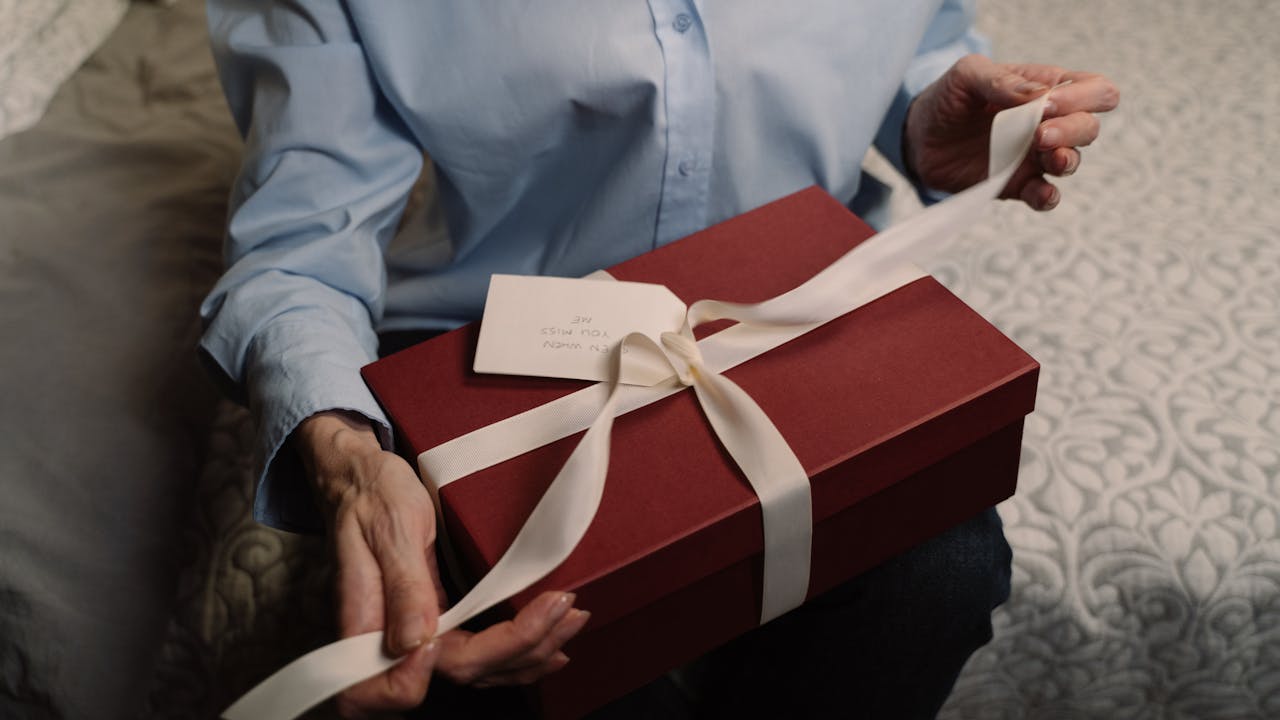 Person receiving a wrapped gift with a happy expression