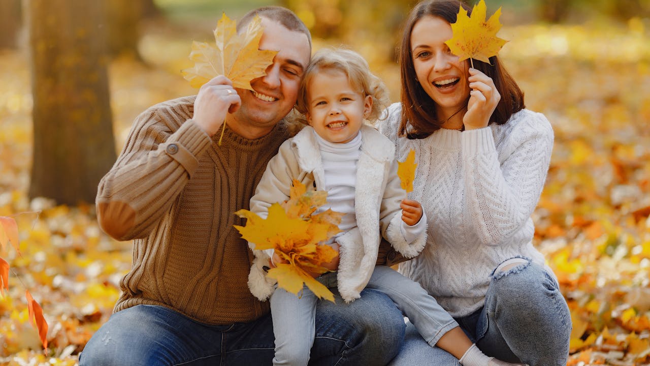 Family dressed in coordinated fall tones enjoying the autumn season together