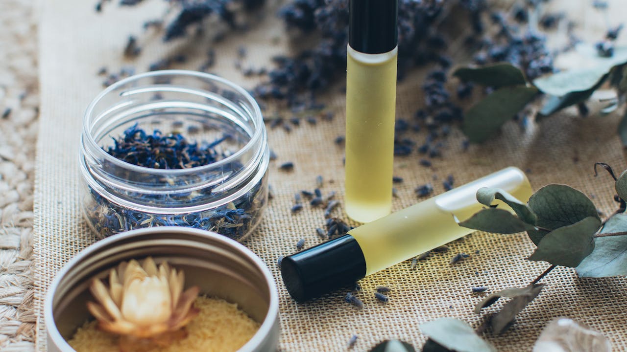 Wellness items including candles, eye masks, and self-care products on a wooden tray