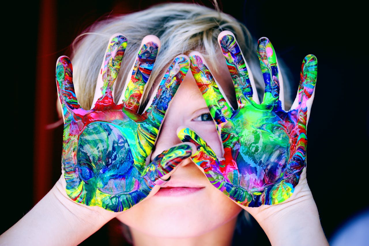 Child focused on a colorful arts and crafts project