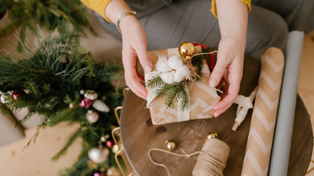 Thoughtful gift wrapped in brown paper with cotton flowers