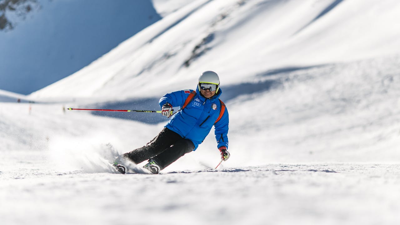 Ski goggles and winter equipment laid out on wooden surface
