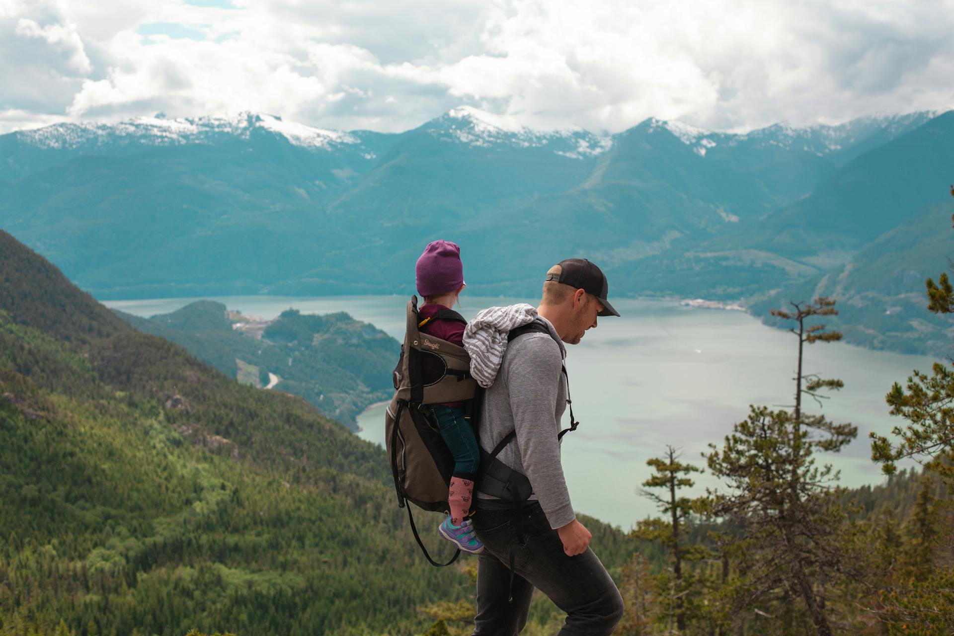 Father and child hiking together in the mountains, outdoor adventure and bonding experience