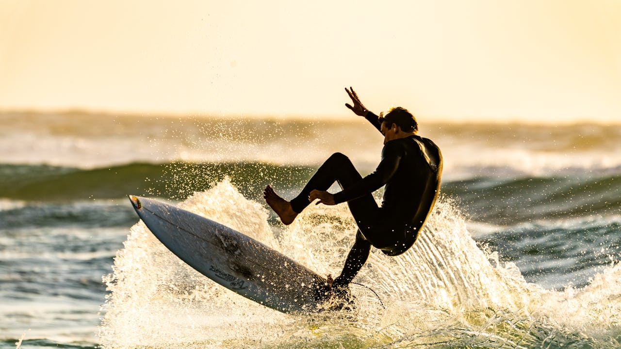 Surfer riding a powerful ocean wave at sunrise