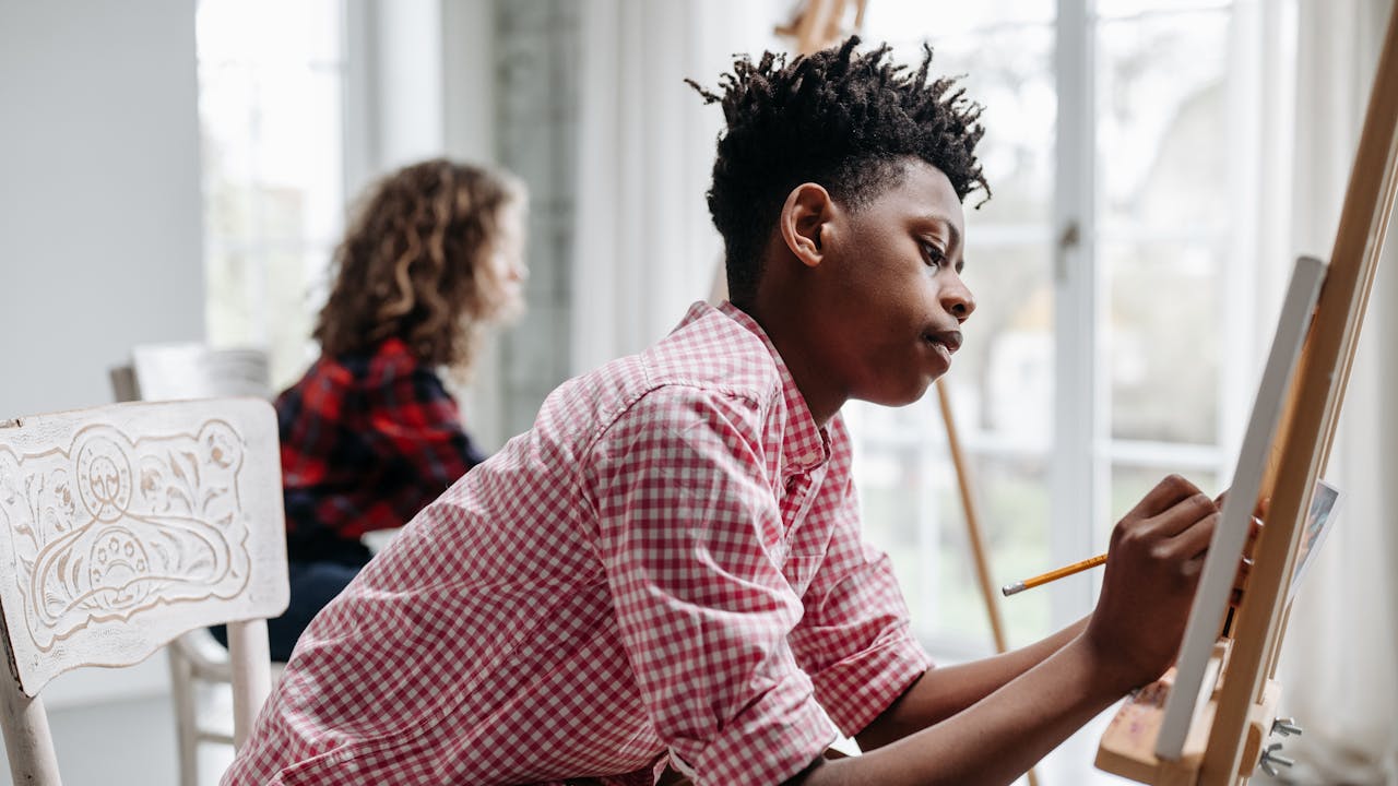 Art students working on paintings in a bright studio environment