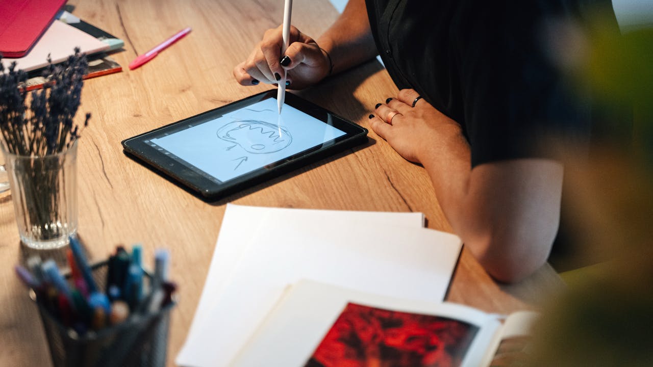 Person drawing on a digital tablet in a creative workspace