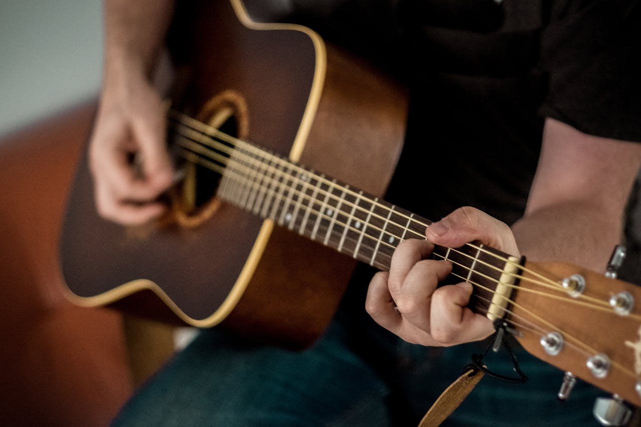 Acoustic guitar player with instrument in warm lighting