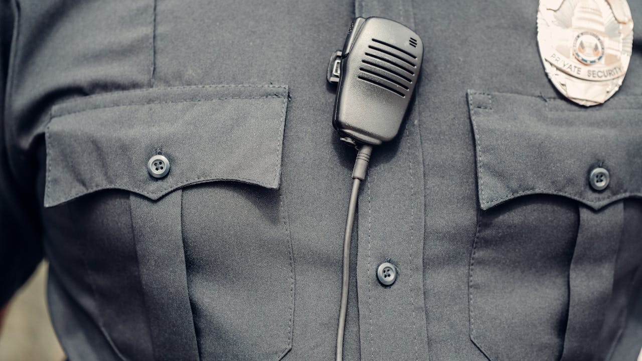 Law enforcement officer in uniform with radio and badge visible on chest