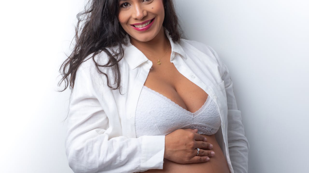 Maternity portrait of smiling pregnant woman in warm natural light