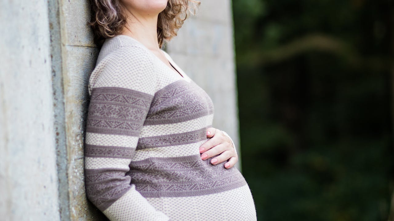 Portrait of a pregnant woman outdoors in warm natural light