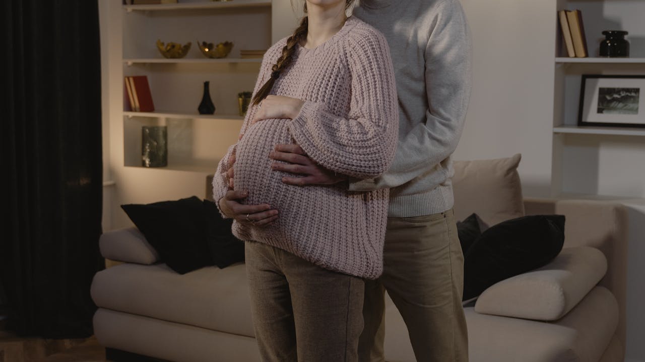 Happy couple embracing during pregnancy, soft natural light