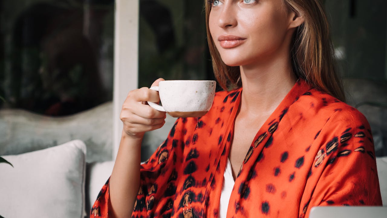 Woman relaxing in cozy robe with cup of tea