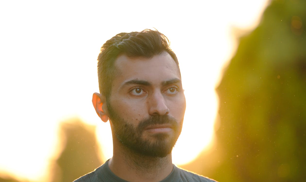 Golden hour outdoor senior portrait of young man in field
