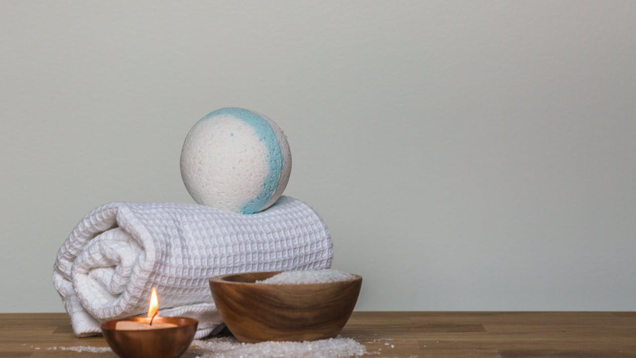 Spa products with bath bomb, candle, and bath salts for self-care gift basket