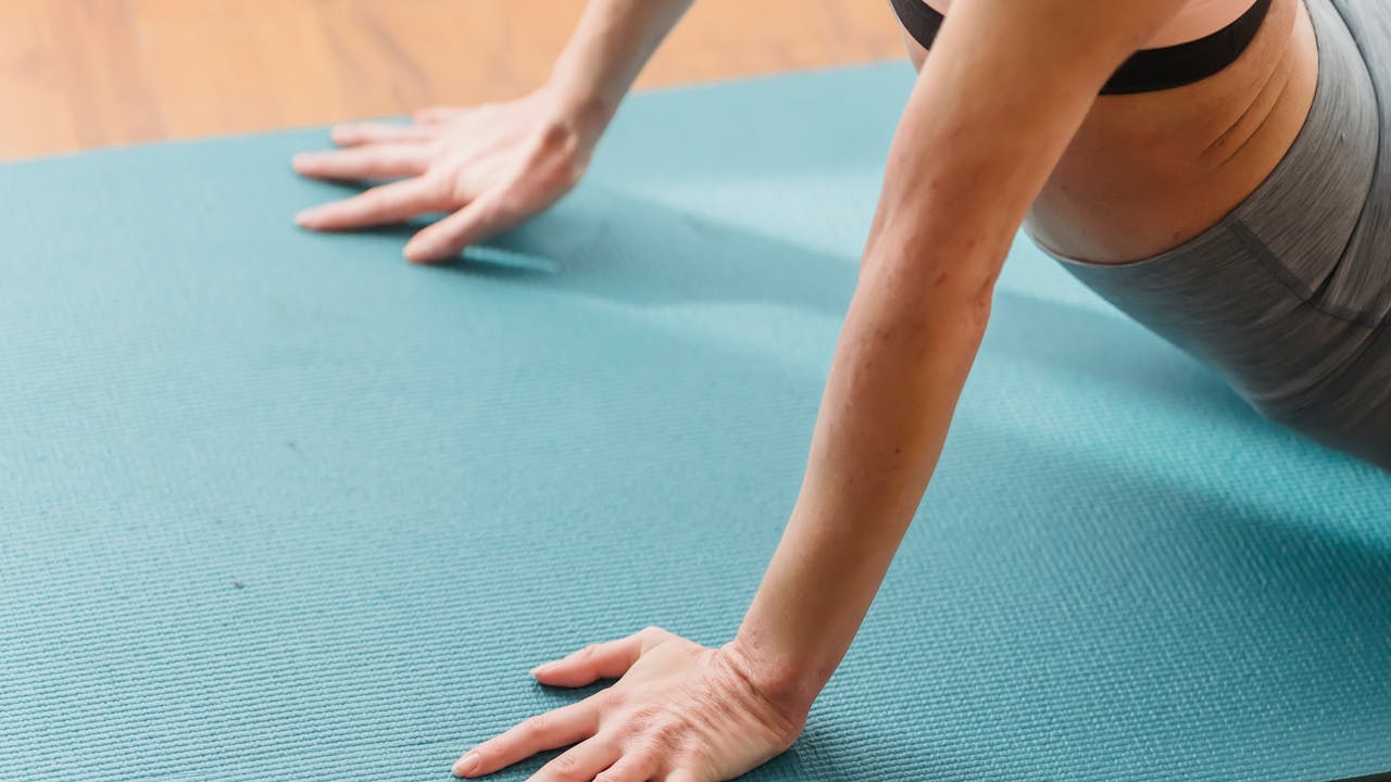 Woman practicing yoga on a mat in a bright studio